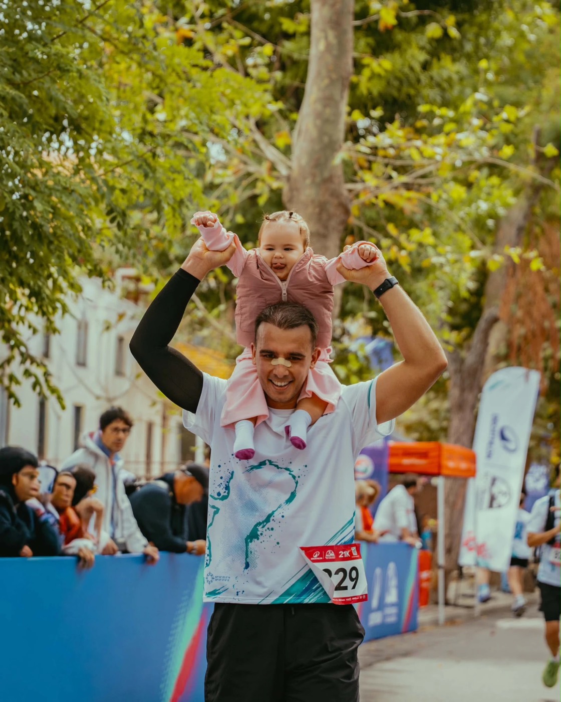 Büyükada Yarı Maratonu'nda bitişe kızını omuzlarında taşıyarak koşan bir koşucu